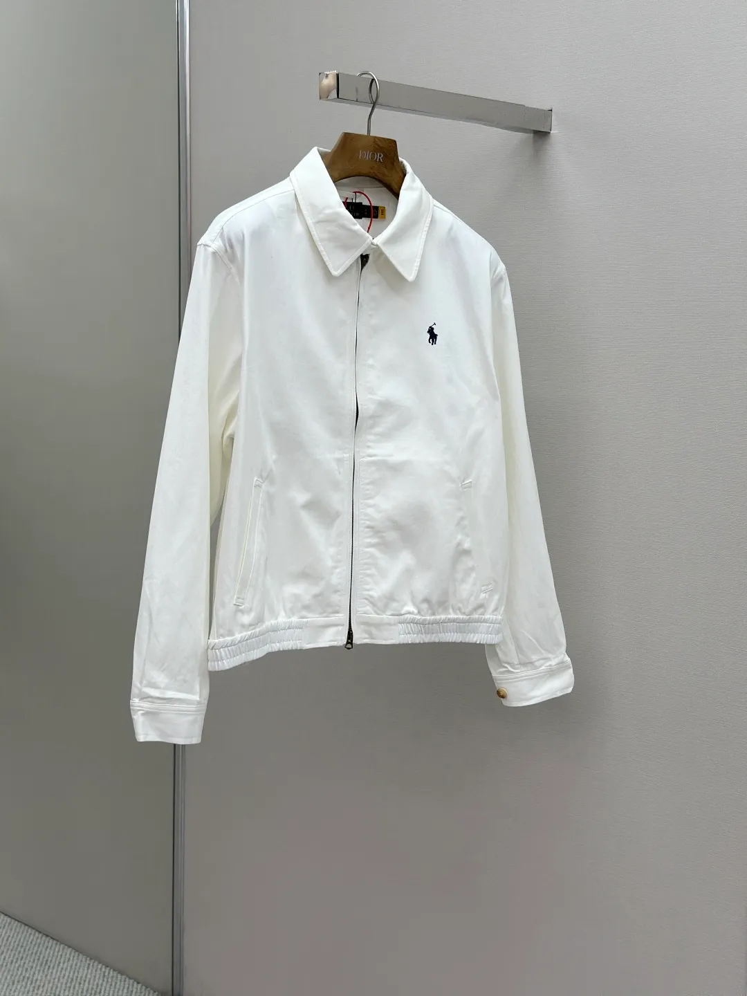 P480 Ralph Lauren embroidered zipper jacket. Customized cloud-velvet white twill cotton. Soft and silky. Comfortable against the skin. Dressed in pure white. Exuding innate elegance. Exquisite indigo pony logo embellished with it. Fully recognizable. Bringing an atmosphere of freedom and vitality. Pure and smart color symphony. Reconstructing classics with neat silhouettes and defining modern relaxation with versatile genes. Process 1: Using imported machine embroidery technology. Use advanced computer control systems and precision mechanical components to achieve iconic pony embroidery operations with high precision and smooth and delicate lines. Process 2: Template machine bag opening. The preset template guides the position, shape and size of the bag opening. The accuracy ensures the quality of the bag opening effect. Process 3: The hem is made in one go using a three-needle waist-drawing machine. The elastic band and fabric are sewn together in the same process using the machine's special needle position and feeding mechanism. The three-needle design is stronger and can evenly distribute pressure. Ensure that the elastic band and the fabric are closely attached. Process 4: The fabrics are washed carefully and have a better hand feel. Not easy to deform, not easy to shrink, not easy to fade, and maintain long-term beauty. Accessories: Customized Ralph Lauren engraved buckle, Customized Ralph Lauren bronze zipper, Customized Ralph Lauren trademark. Version: Fitted version. Size: S M L XL